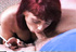 Older chick with reddish hair sucks a hairy guy's dick while also puffing on a cig.