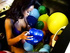 Ebony in a balloon-filled tub plays with the latex spheres while smoking a cig.