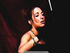 Extravagant brunette in a black top and gloves smoking with cigarette-holder