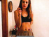 Long-haired brunette in a top and shorts smoking while drinking coffee