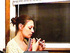 Brunette housewife with a hair knot smoking at the window