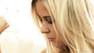 attractive blonde bends forward
